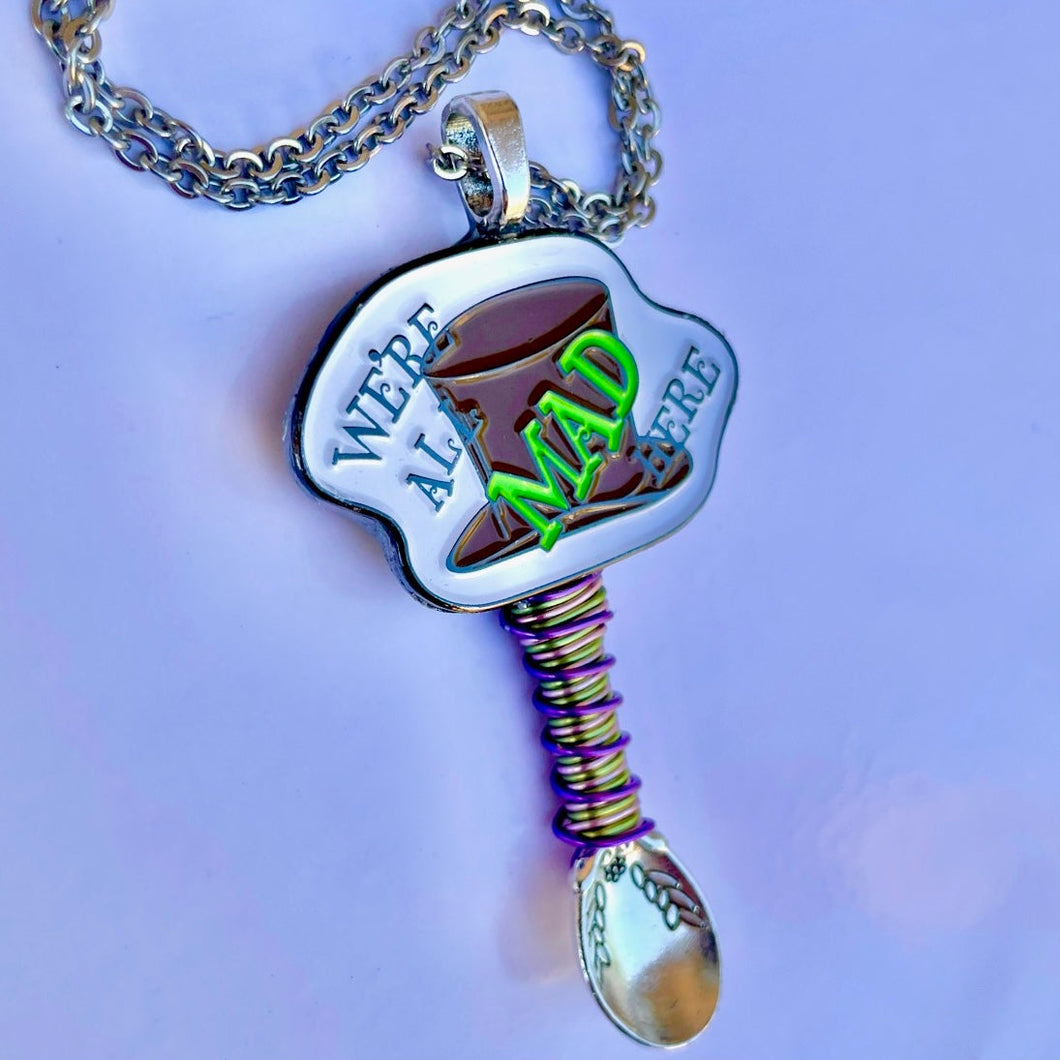 Mad Hatter Pendant Tiny Festival Spoon Necklace with a 'We're all MAD Here' centerpiece charm and matching wire wrapping on a larger size silver spoon scoop base.