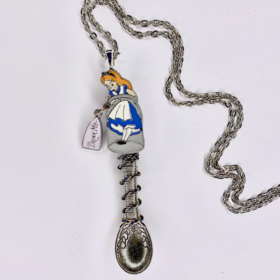 Custom Alice 'Drink Me' Tiny Festival Spoon Necklace featuring a small Alice in a bottle centerpiece charm with matching wire wrapping on a large scoop size silver tea spoon pendant base.